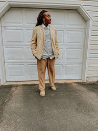 Full length of young woman standing against wall