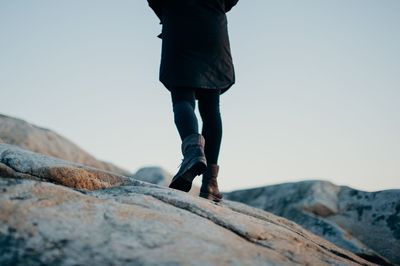 Low section of man standing on rock