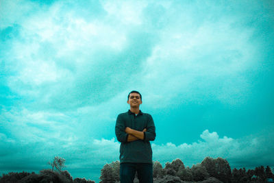 Portrait of young man standing against blue sky