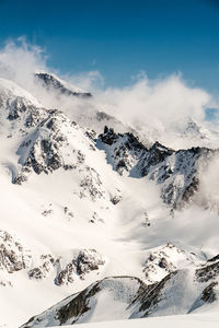 Scenic view of snow covered mountains against sky