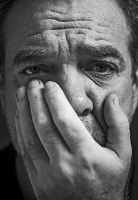 Close-up portrait of mature man against black background