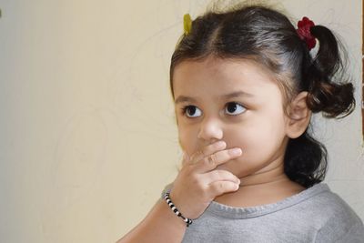 Portrait of cute girl against wall