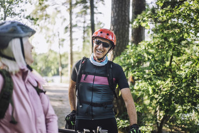 Happy male cyclist talking to senior female friend