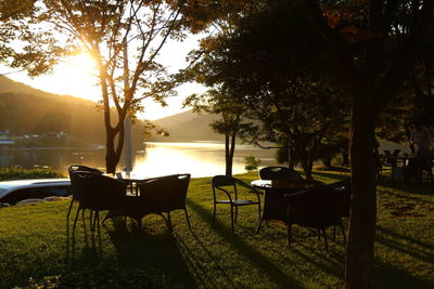 Empty chairs and table at park during sunset