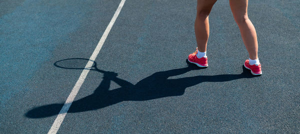 Low section of woman standing on road