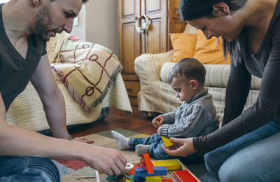 Parents playing with son while sitting at home