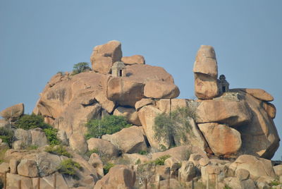 Low angle view of rocks against clear sky
