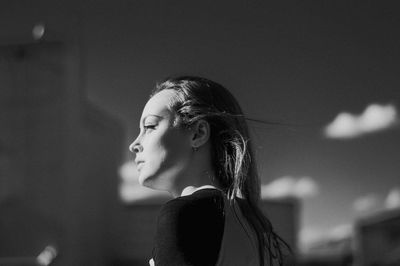 Portrait of a young woman looking away outdoors