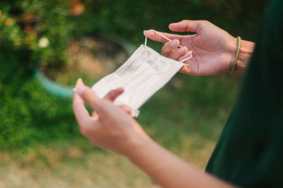 Midsection of woman holding paper outdoors