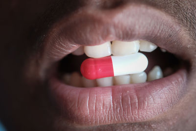 Person mouth with pill or capsule , close up