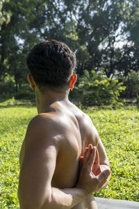 Latin american man doing yoga posture, yoga posture, bee backwards prsthatah brahmara, forest