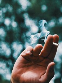 Close-up of hand holding cigarette