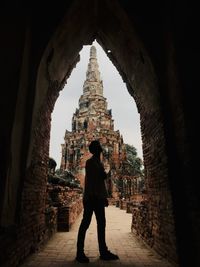 Silhouette man standing in front of ancient temple