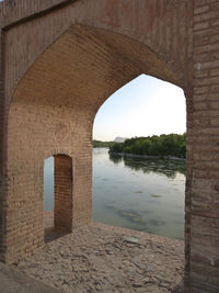 River against clear sky seen from archway