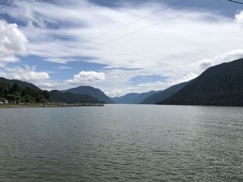 Scenic view of lake by mountains against sky