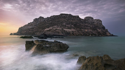 Rock formations in sea against sky