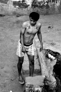 Portrait of shirtless boy standing outdoors