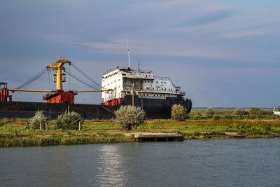 Built structure by water against sky