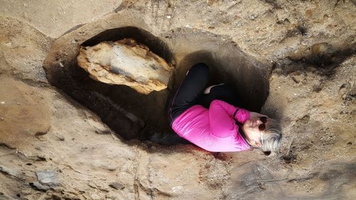 High angle view of woman relaxing on rock