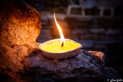 Close-up of lit candle on table