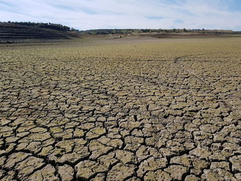 Surface level of barren land against sky