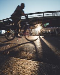 Silhouette of people riding bicycle on road