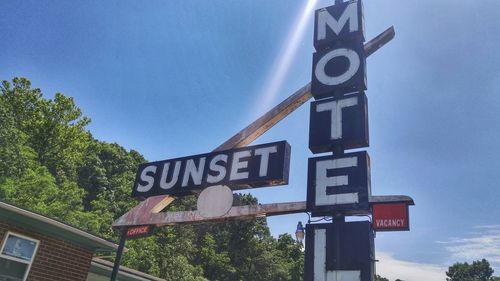 Low angle view of road sign against blue sky