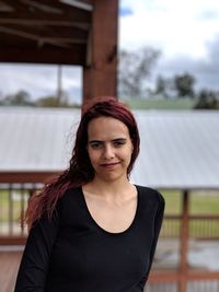 Portrait of smiling young woman standing on porch