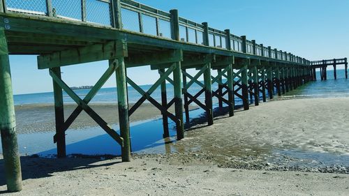 Pier on shore at beach against sky