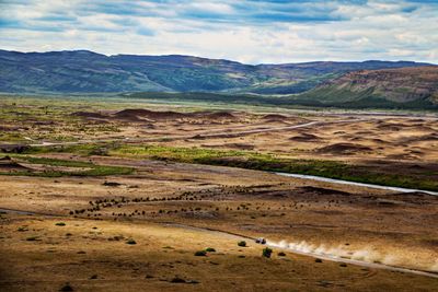 Scenic view of landscape against cloudy sky