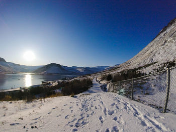 Scenic view of snowcapped mountains against clear blue sky