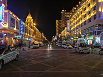 Illuminated city street and buildings at night