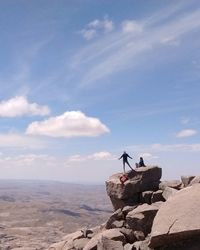 Man on rock against sky