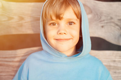 Portrait of face happy smiling candid five year old kid boy in blue hoodie in a hood