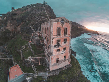 Built structure by sea against sky