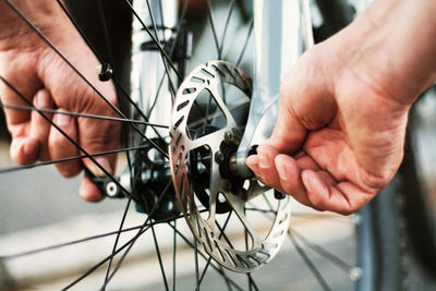 Cropped hand of man repairing bicycle