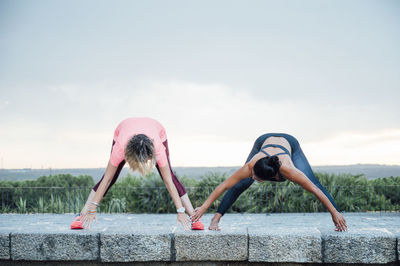 Woman teaching yoga to senior woman