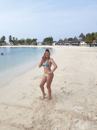 Portrait of smiling young woman standing at beach