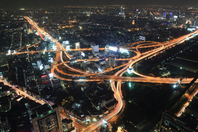 High angle view of illuminated highway amidst buildings in city at night