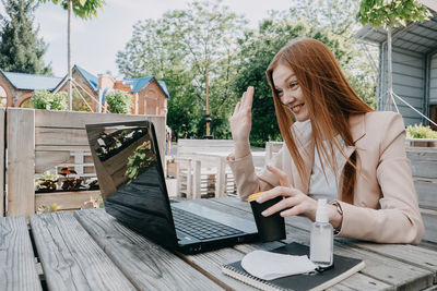 Businesswoman working on the laptop outdoors. businesswoman having video call, remote meeting while