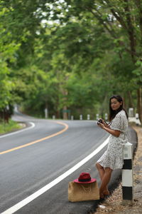 Woman using mobile phone on road