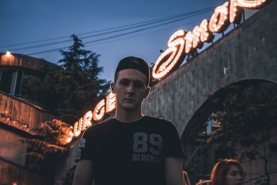 Low angle view of man standing by illuminated building