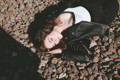 High angle view of young woman lying on stones