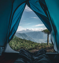 Low section of man relaxing against sky