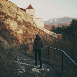 Full length rear view of woman walking on street