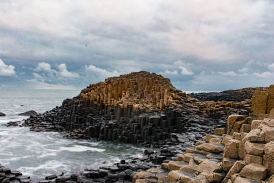 View of rocky beach against clouds