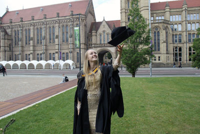 Woman standing by buildings in city