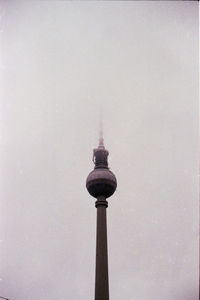 Low angle view of communications tower in city