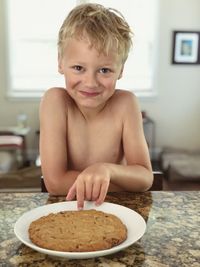 Portrait of shirtless boy with food at home