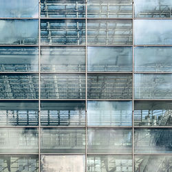 Low angle view of glass building against sky